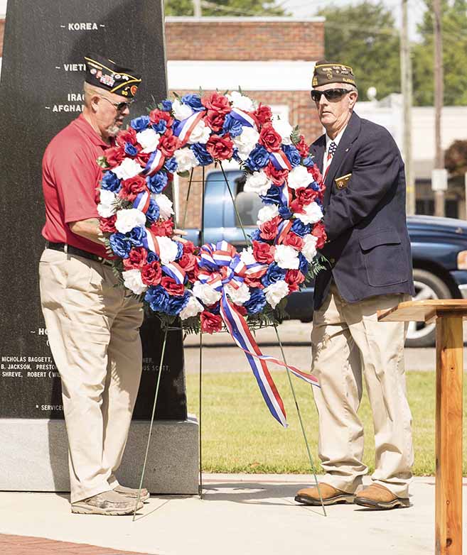 Commander Dave Graham, left, and Commander Billy Gates place the wreath at the monument.